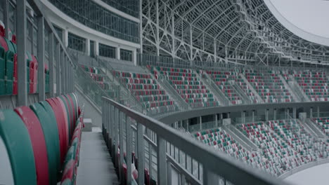 Empty-outdoor-football-soccer-stadium-field-covered-with-snow-in-winter,-light-snowfall.-Shot-with-2x-anamorphic-lens